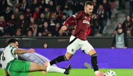 Na zdjęciu Lukas Haraslin w bordowej koszulce Sparty Praga. Wślizgiem atakuje go piłkarz ubrany na biało-zielono.