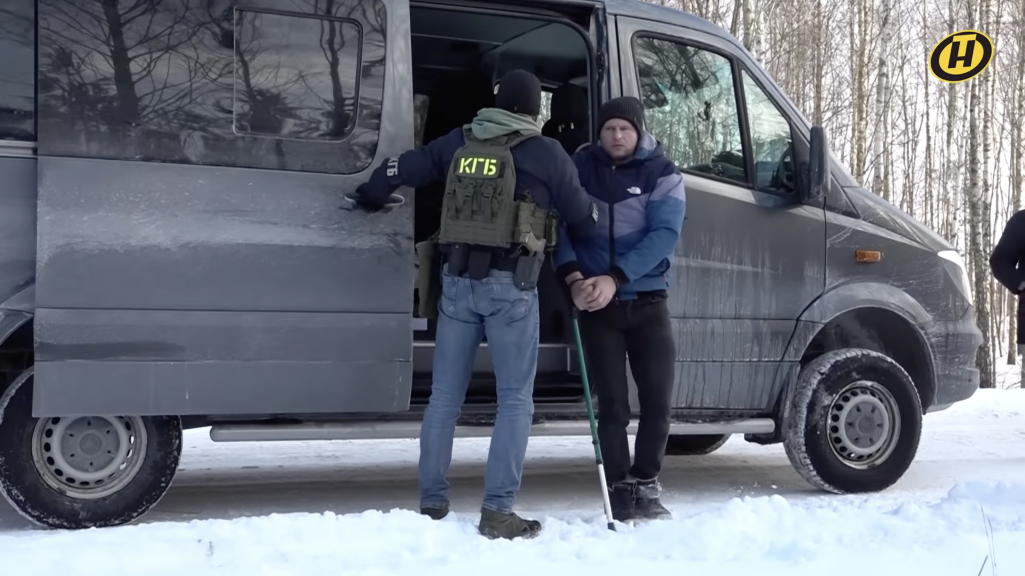 Дзмітрый Капуза паказвае месца ў лесе, дзе нібыта была схавана выбухоўка. Кадр з фільму тэлеканалу ОНТ. (Скрыншот: Телеканал ОНТ / YouTube)