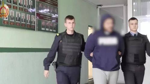 Затрыманы ў Гомлі мараканец у суправаджэнні міліцыянтаў. Скрыншот з відэа: МВД Беларуси / Telegram