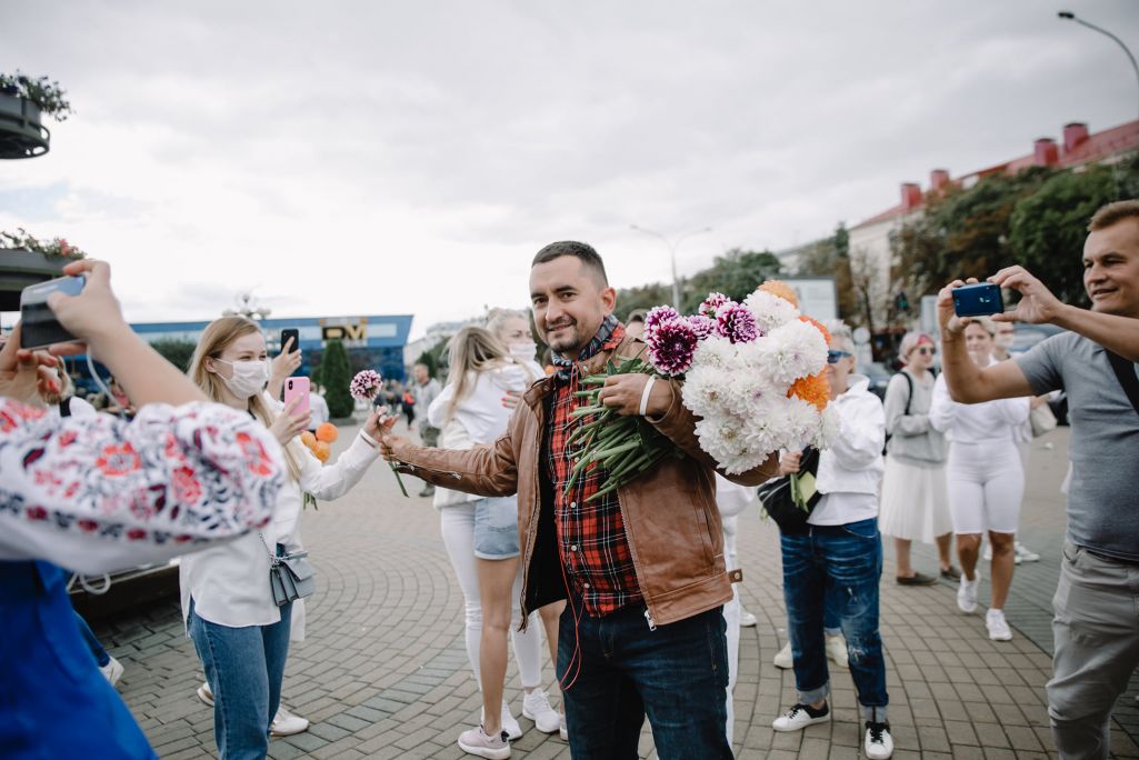 Сцяпан Латыпаў раздае кветкі дзеўчынам, якія стаяць у ланцугу салідарнасці. Менск, Беларусь. 12 жніўня 2020 года. (Фота: VS / Facebook)