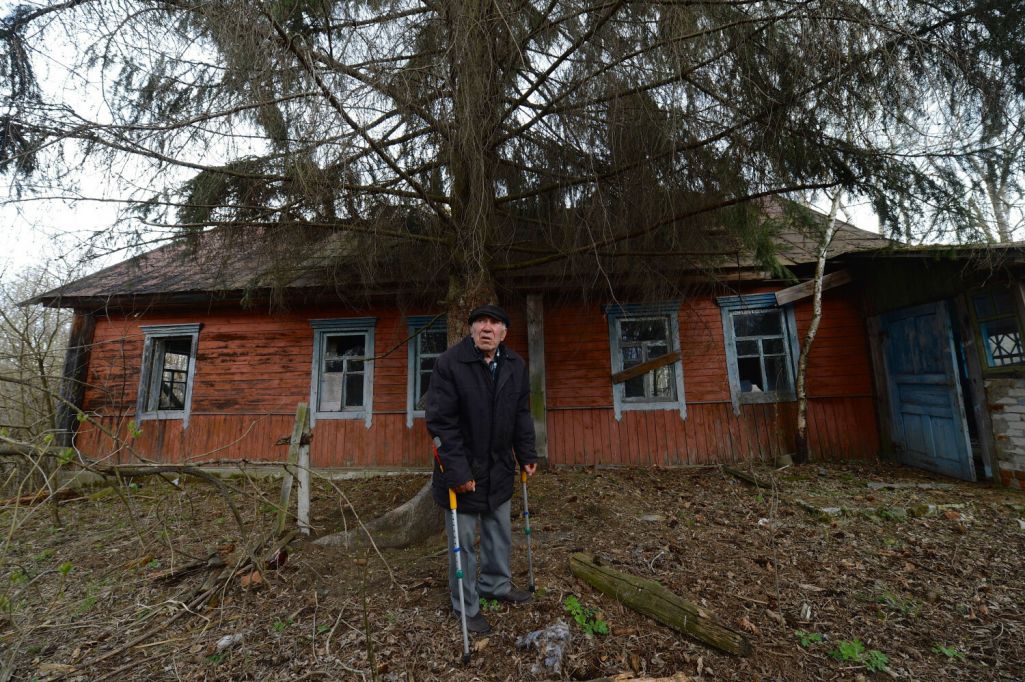Мужчына сталага веку перад сваім закінутым домам у вёсцы Арэвічы, Гомельская вобласць, Беларусь. 21 красавіка 2015 года. Фота: Stringer / AFP / East News