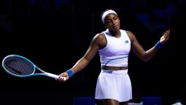 Coco Gauff (fot. Getty Images) Amerykańska tenisistka Coco Gauff, ubrana w biały strój sportowy New Balance, stoi na korcie po meczu, trzymając rakietę w lewej ręce i wykonując gest prawą dłonią, prawdopodobnie wyrażający emocje lub frustrację po akcji. Jest to zdjęcie z turnieju WTA Finals w Rijadzie, gdzie Gauff pokonała Jasmine Paolini 6:3, 6:2 w fazie grupowej.
