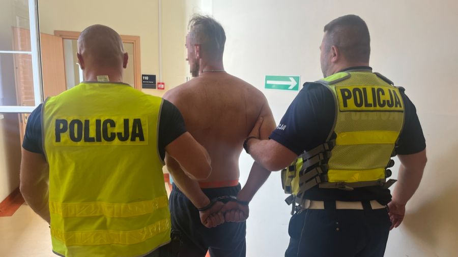 Poszukiwany mężczyzna prowadzony przez policję na komendzie w Kołobrzegu po zatrzymaniu (źródło: KPP w Kołobrzegu)