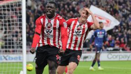 Dwóch piłkarzy Sunderlandu w czerwono-białych pasiastych koszulkach świętuje zdobycie bramki podczas meczu Premier League przeciwko Arsenalowi. W tle widać kibiców na trybunach oraz fragment boiska z piłką